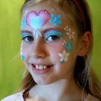 Mädchen mit geschminkten Blumen im Gesicht