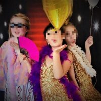 Mädchen werfen KLuftküsse in Glitzerkleidern bei Topmodelparty